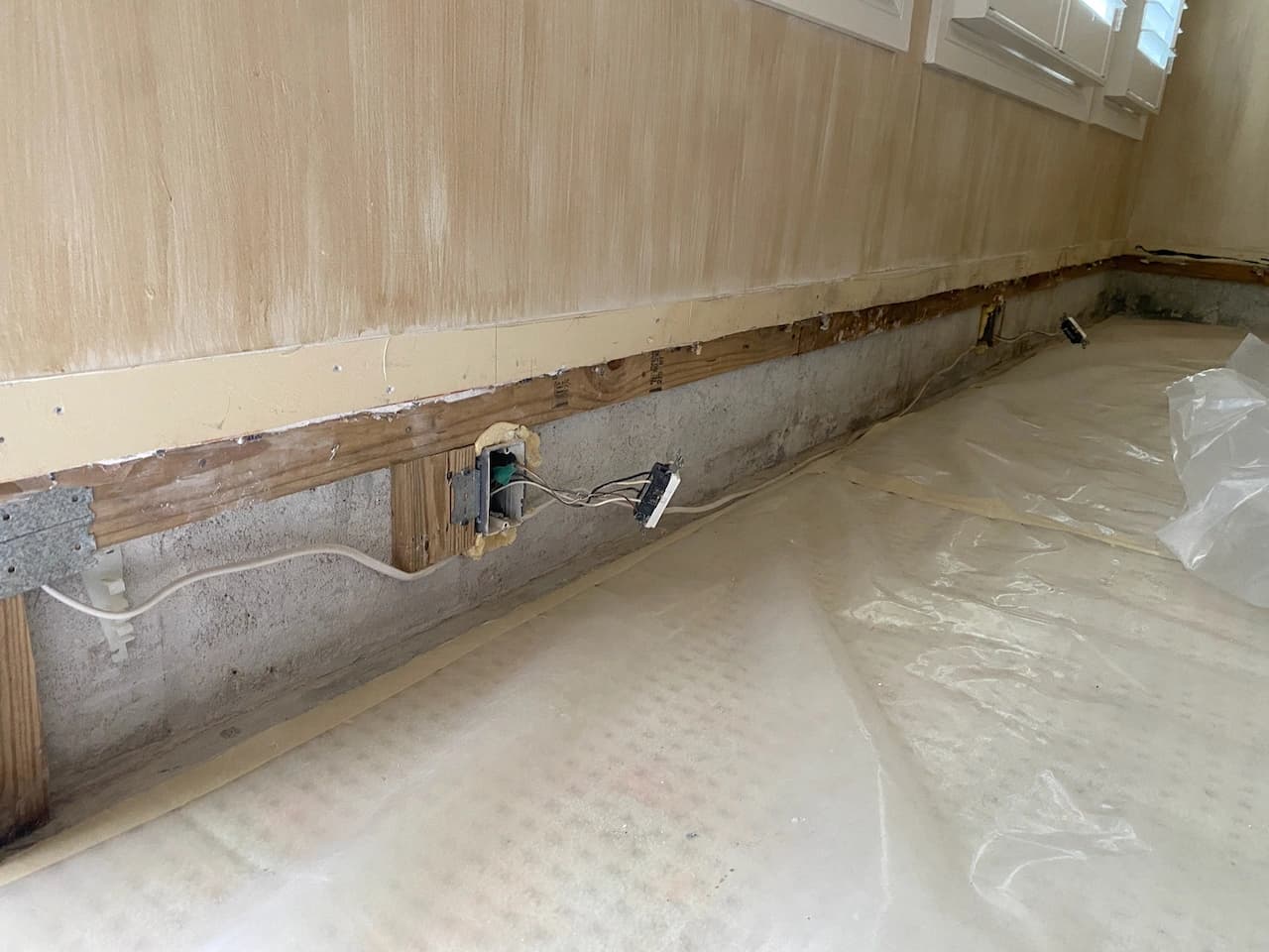Lower wall opened and floor protected during water damage repairs in a Florida home Lower wall opened and floor protected during water damage repairs in a Florida home