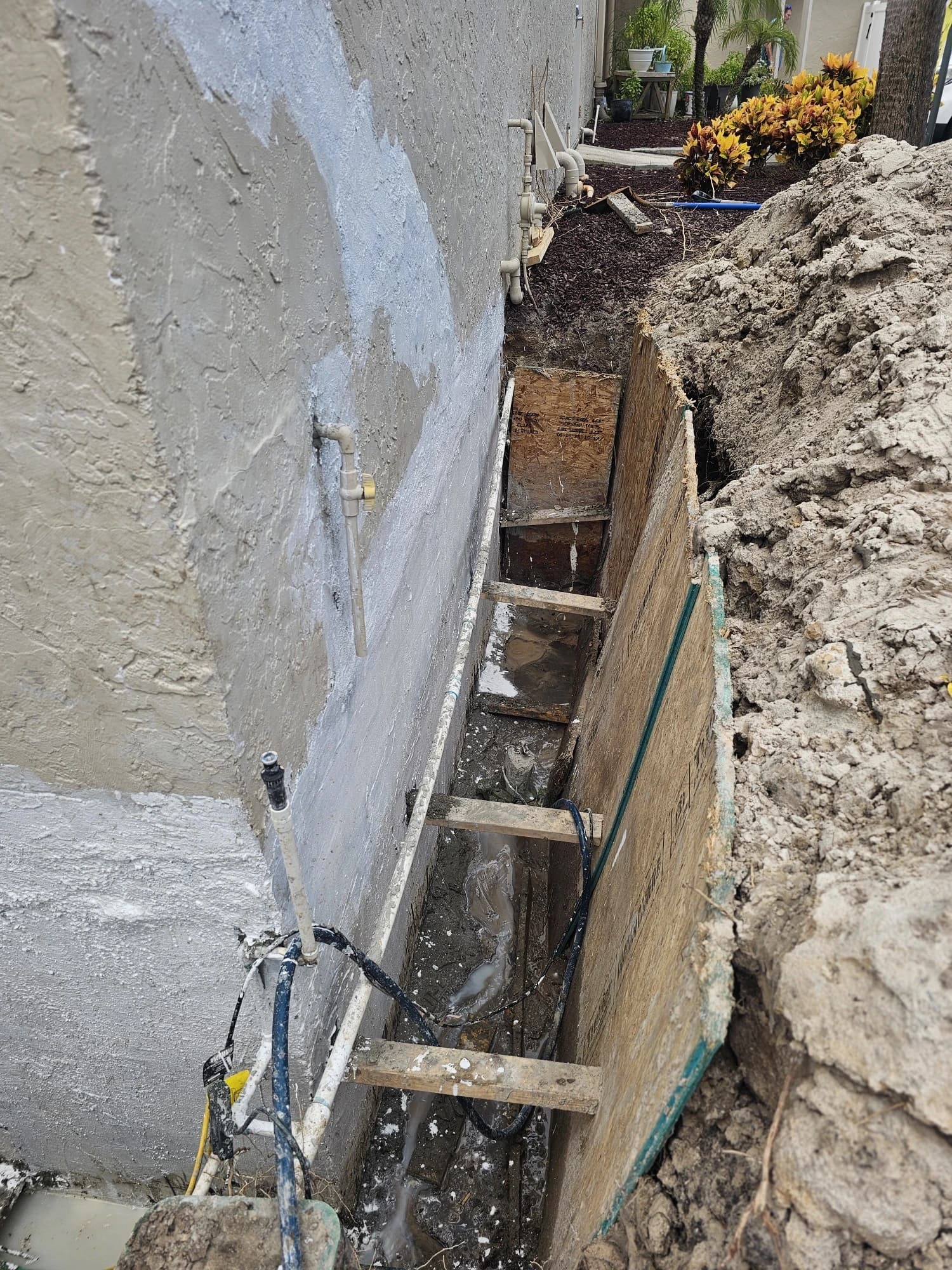 Trench dug beside a concrete block foundation wall so the block can be sealed below grade Trench dug beside a concrete block foundation wall so the block can be sealed below grade