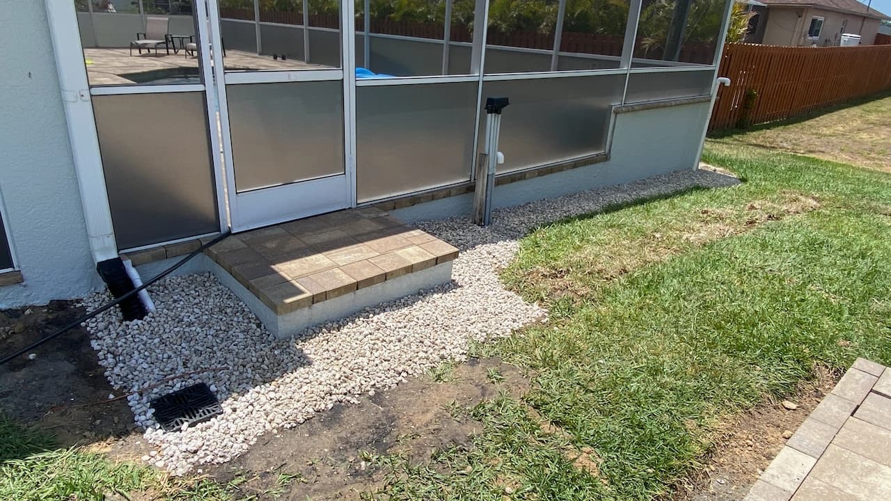Completed exterior drainage and gravel bed beside a Florida screened porch Completed exterior drainage and gravel bed beside a Florida screened porch