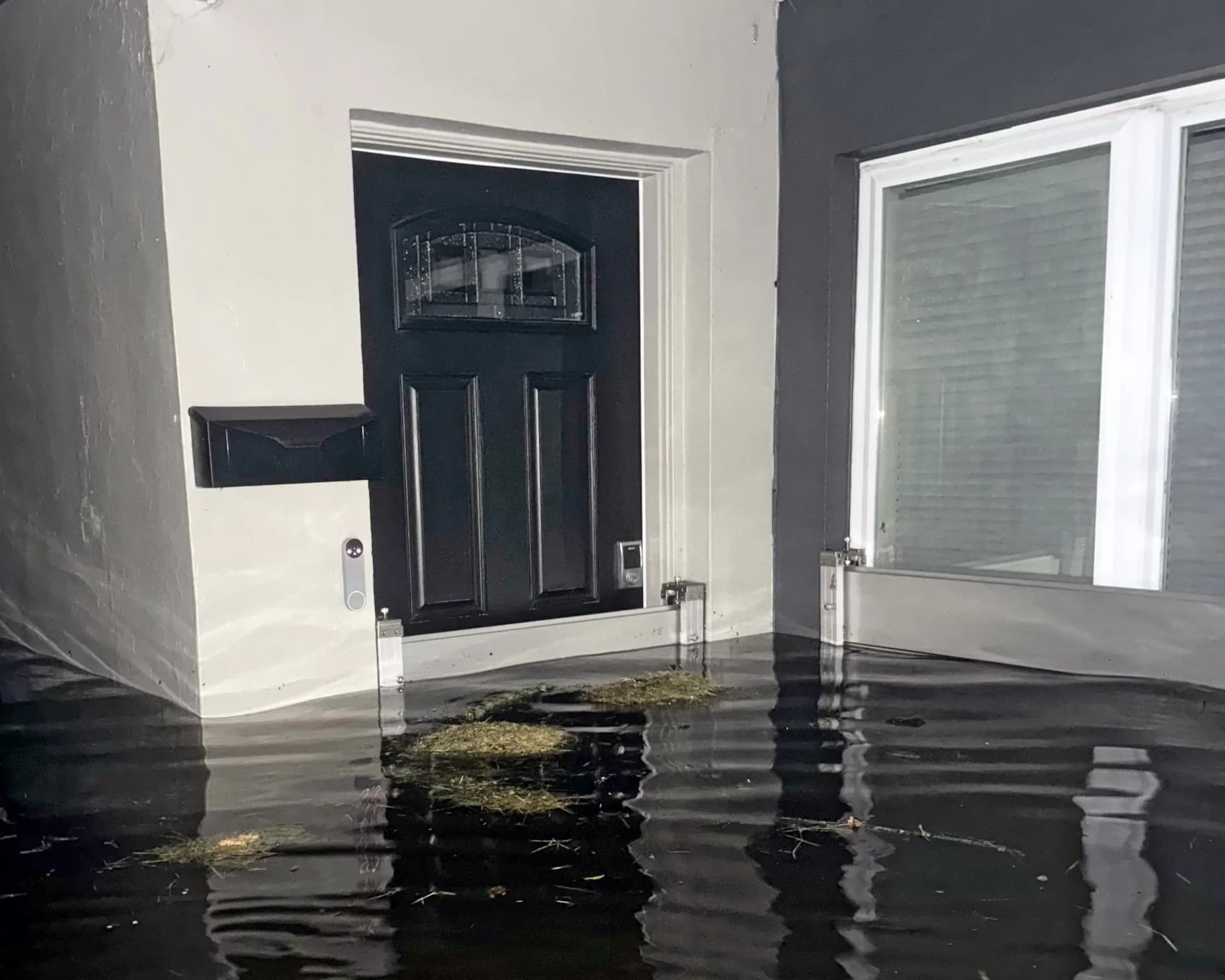 Garrison Hammerhead aluminum flood barriers protecting a Florida home's doors during post-hurricane flooding Garrison Hammerhead aluminum flood barriers protecting a Florida home's doors during post-hurricane flooding
