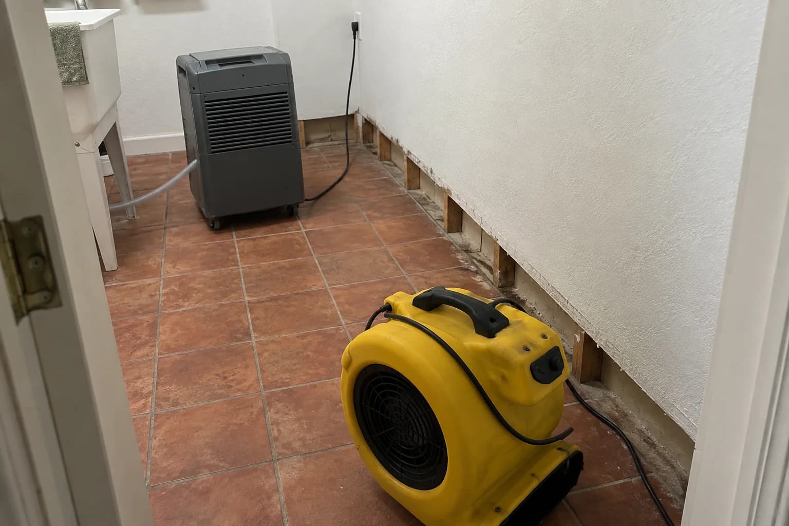 Air mover and dehumidifier positioned near an opened wall in a tiled room Air mover and dehumidifier positioned near an opened wall in a tiled room
